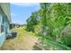 View of the green backyard showing proximity to the home and surrounding trees at 12264 Grizzly Ln, New Port Richey, FL 34654