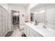 Bright bathroom featuring double sinks, large mirror, and access to a walk-in closet at 12264 Grizzly Ln, New Port Richey, FL 34654
