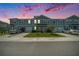 Exterior view of townhomes at twilight, featuring a well manicured lawn at 12264 Grizzly Ln, New Port Richey, FL 34654
