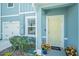 Inviting entryway with a yellow front door, manicured bushes, and vibrant orange flowers at 12264 Grizzly Ln, New Port Richey, FL 34654