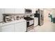Well-equipped kitchen featuring stainless steel appliances and white cabinetry at 12264 Grizzly Ln, New Port Richey, FL 34654
