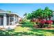 View of the backyard with lush landscaping and the screened-in lanai at 1257 Lyndhurst Greens Dr, Sun City Center, FL 33573