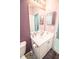Bathroom with a toilet, a sink and vanity, a large mirror, and purple walls at 1257 Lyndhurst Greens Dr, Sun City Center, FL 33573