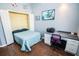 Bright bedroom with hardwood floors, closet, a workspace with desk, chair, and two artistic wall hangings at 1257 Lyndhurst Greens Dr, Sun City Center, FL 33573