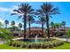 Community center featuring a circular drive, water feature, and lush landscaping at 1257 Lyndhurst Greens Dr, Sun City Center, FL 33573