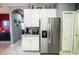 Bright kitchen with stainless steel refrigerator, white cabinets, and a view to other living areas at 1257 Lyndhurst Greens Dr, Sun City Center, FL 33573