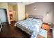 Calm main bedroom with wood floors, blue-patterned bedding, and views to the en-suite bathroom at 1257 Lyndhurst Greens Dr, Sun City Center, FL 33573