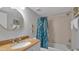 Bathroom featuring granite countertop, round mirror, and tub with shower at 13720 Gulf Blvd # 305, Madeira Beach, FL 33708