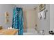 Bathroom featuring granite countertop, round mirror, and tub with shower at 13720 Gulf Blvd # 305, Madeira Beach, FL 33708