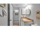 Bathroom featuring granite countertop, framed mirror, and seashell accents at 13720 Gulf Blvd # 305, Madeira Beach, FL 33708