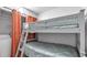 Cozy bedroom with gray bunk beds, orange curtains, and built-in storage at 13720 Gulf Blvd # 305, Madeira Beach, FL 33708