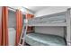 Cozy bedroom with gray bunk beds, orange curtains, and built-in storage at 13720 Gulf Blvd # 305, Madeira Beach, FL 33708