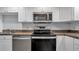 A modern kitchen with stainless steel appliances including a dishwasher and electric range at 13720 Gulf Blvd # 305, Madeira Beach, FL 33708