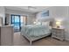 Serene bedroom features a balcony with ocean views, a king-sized bed, and coastal-inspired decor at 13720 Gulf Blvd # 305, Madeira Beach, FL 33708