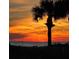 Experience breathtaking sunset views over the ocean with swaying palm trees and vibrant colors at 13720 Gulf Blvd # 305, Madeira Beach, FL 33708