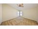 A large bedroom featuring carpet, fan, and two windows with backyard views at 1604 Storington Ave, Brandon, FL 33511