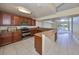 Open kitchen featuring granite countertops, wood cabinetry, and stainless steel appliances overlooking the pool at 1604 Storington Ave, Brandon, FL 33511