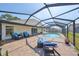 Relax on the brick patio by the screened-in pool area with outdoor seating, a beautiful lake view, and sunny skies at 1604 Storington Ave, Brandon, FL 33511