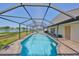 Sparkling pool enclosed within a screened lanai, featuring a brick patio and scenic lake views for relaxation at 1604 Storington Ave, Brandon, FL 33511