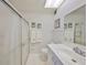 Clean bathroom with glass shower doors, decorated with ocean themed art and matching towels at 1809 Haverford Ave, Sun City Center, FL 33573