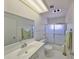 Bright bathroom with a glass enclosed shower, vanity with mirror and towels hanging on the wall at 1809 Haverford Ave, Sun City Center, FL 33573