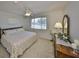 Bedroom featuring a large window, ceiling fan, and a comfortable bed with ornate wooden headboard at 1809 Haverford Ave, Sun City Center, FL 33573