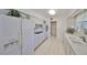Bright kitchen with white cabinets, white appliances and neutral countertops at 1809 Haverford Ave, Sun City Center, FL 33573