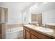 Bathroom featuring double sinks, large mirror, soaking tub, and a glass-enclosed shower at 2122 Richwood Pike Dr, Ruskin, FL 33570