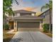 Charming two-story home with a well-manicured lawn, two-car garage and tropical landscaping at 2122 Richwood Pike Dr, Ruskin, FL 33570