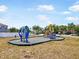 Community playground with modern blue and yellow equipment, set in a gravel base with surrounding grassy area at 2122 Richwood Pike Dr, Ruskin, FL 33570