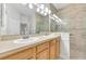 Bathroom with double sinks, large mirror, and updated glass-enclosed shower at 215 Oceania Ct, Apollo Beach, FL 33572