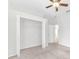 Clean, carpeted bedroom showcasing an open closet and an adjacent doorway, providing functionality and access at 215 Oceania Ct, Apollo Beach, FL 33572
