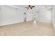 Open living room with neutral tile floors, ceiling fan, and ample natural light at 215 Oceania Ct, Apollo Beach, FL 33572