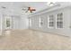 Spacious living area with a tray ceiling, tile floors, and ample natural light from large windows at 215 Oceania Ct, Apollo Beach, FL 33572