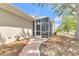 Home's screened porch is accessible by a brick walkway from the side yard at 215 Oceania Ct, Apollo Beach, FL 33572