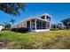 Exterior view of the rear of the house with screened in patio with lush green grass at 2246 Sifield Greens Way # 36, Sun City Center, FL 33573