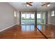 Bright bedroom features wood floors, ceiling fan, and large sliding glass doors to the balcony with a water view at 2246 Sifield Greens Way # 36, Sun City Center, FL 33573