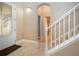 Foyer with decorative glass door, tiled floor, staircase and view to a bathroom; dark mat at 2246 Sifield Greens Way # 36, Sun City Center, FL 33573