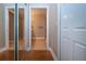 Hallway with access to bathroom with mirrored closet and neutral walls and tile flooring at 2246 Sifield Greens Way # 36, Sun City Center, FL 33573