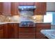 This home features a Wolf range with stainless steel hood and granite countertops and backsplash at 2246 Sifield Greens Way # 36, Sun City Center, FL 33573