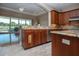 Open kitchen boasts granite counters, tile flooring, a sink, and view of a large, screened lanai at 2246 Sifield Greens Way # 36, Sun City Center, FL 33573