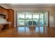 Open-concept living area featuring wood floors and sliding doors to the outdoor patio with a lake view at 2246 Sifield Greens Way # 36, Sun City Center, FL 33573