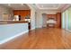 Open-concept living room with wood floors, kitchen view, and access to outdoor patio at 2246 Sifield Greens Way # 36, Sun City Center, FL 33573