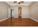Large main bedroom with hardwood floors, tray ceiling, neutral walls, and arched doorway at 2246 Sifield Greens Way # 36, Sun City Center, FL 33573