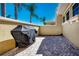 Paver patio with grill, surrounded by yellow walls and featuring tall palm trees in the background at 2246 Sifield Greens Way # 36, Sun City Center, FL 33573