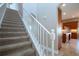 Carpeted staircase with a white railing leading to an open kitchen area at 2246 Sifield Greens Way # 36, Sun City Center, FL 33573