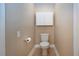 Toilet with storage overhead, tan walls, tiled floors, and traditional toilet paper holder at 2246 Sifield Greens Way # 36, Sun City Center, FL 33573
