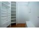 Spacious walk-in closet with custom shelving, drawers, bench, and lighting at 2246 Sifield Greens Way # 36, Sun City Center, FL 33573