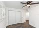 This bedroom features a ceiling fan, wood-look floors, and a window with blinds at 2650 Countryside Blvd # A104, Clearwater, FL 33761