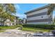 View of condo building complex with multiple units, paved walkway and green grass at 2650 Countryside Blvd # A104, Clearwater, FL 33761